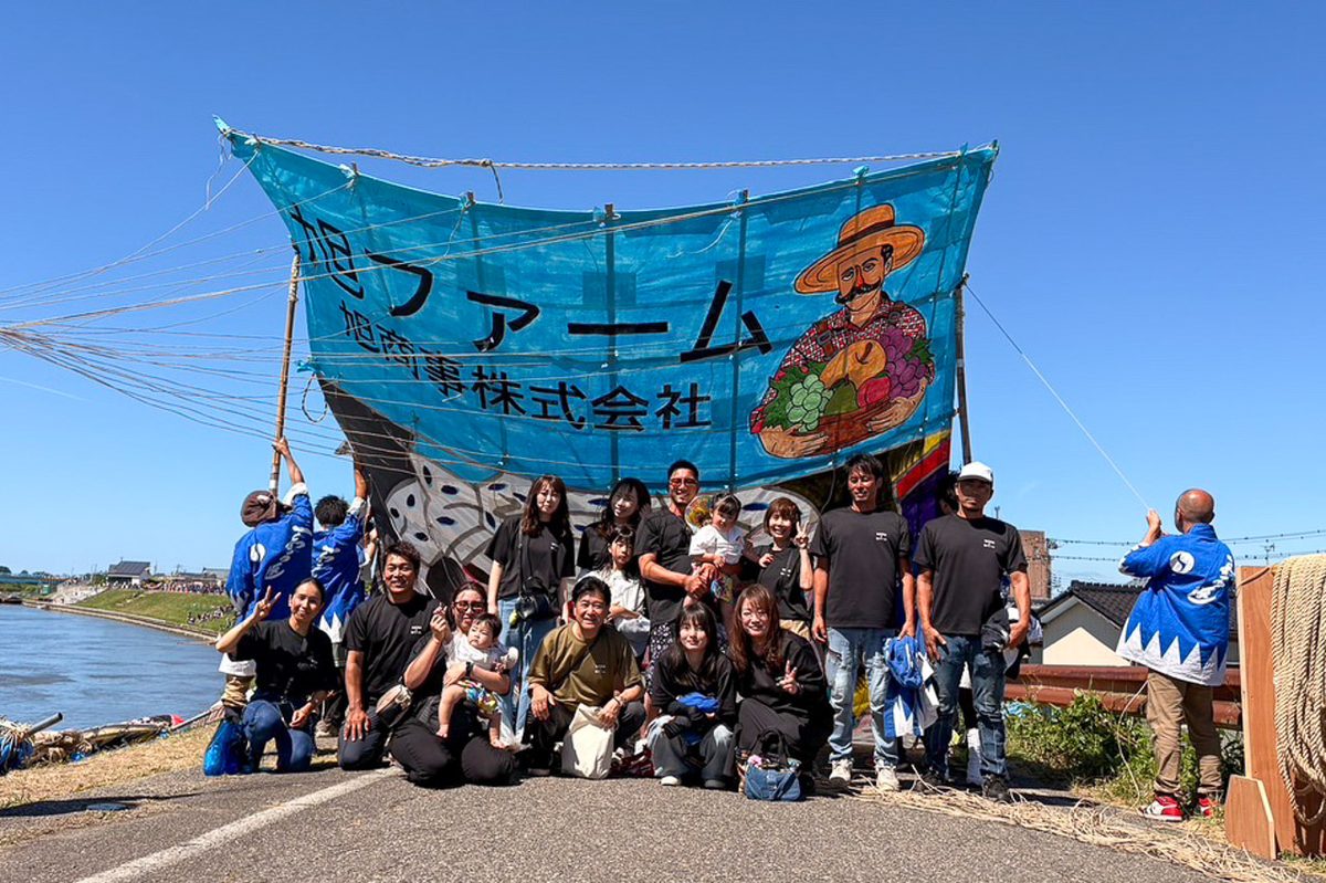 大凧の前に集まった仲間たちの記念写真